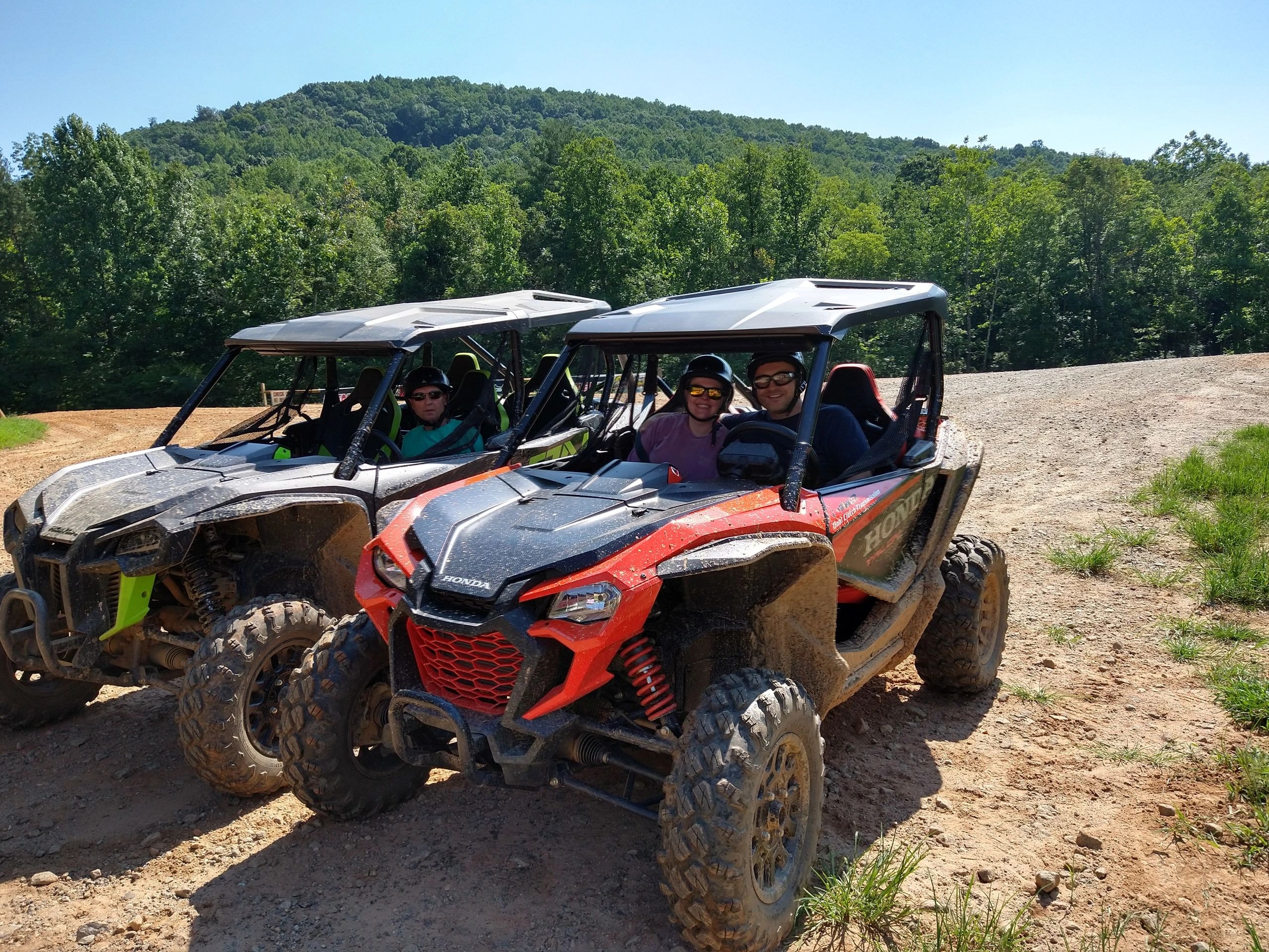 UTVs parked on mountain trail with scenic valley view