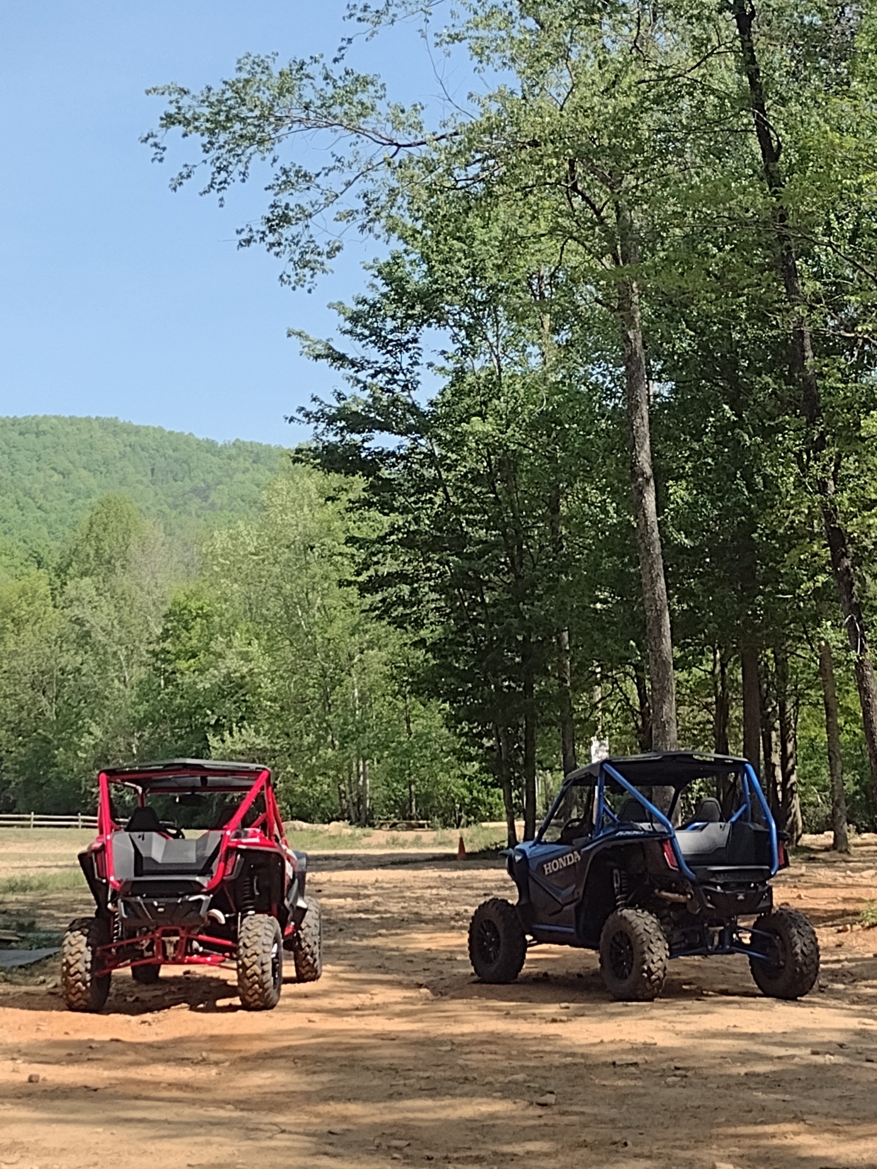 UTV navigating forest trail with two riders